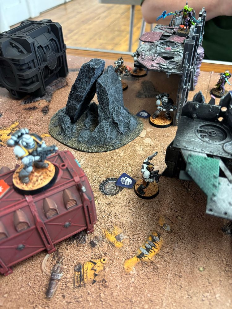 A Space Marine looks down at units on a Kl Team board game 