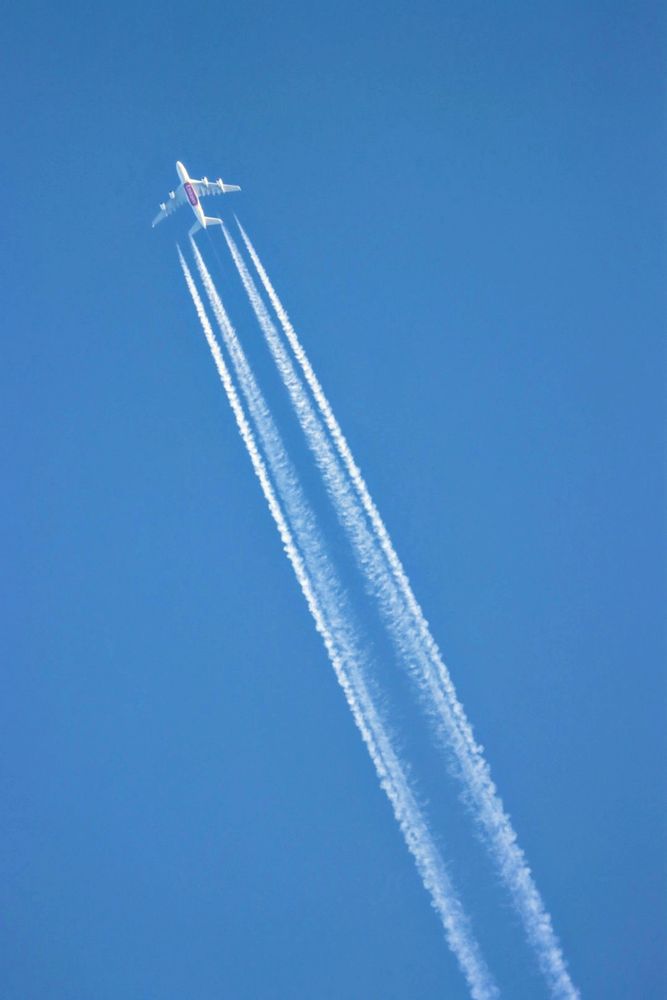 Emirates A380 with four contrails from below. 