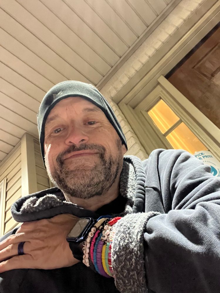 Me bundled up for Halloween showing an arm full of Taylor Swift bracelets.