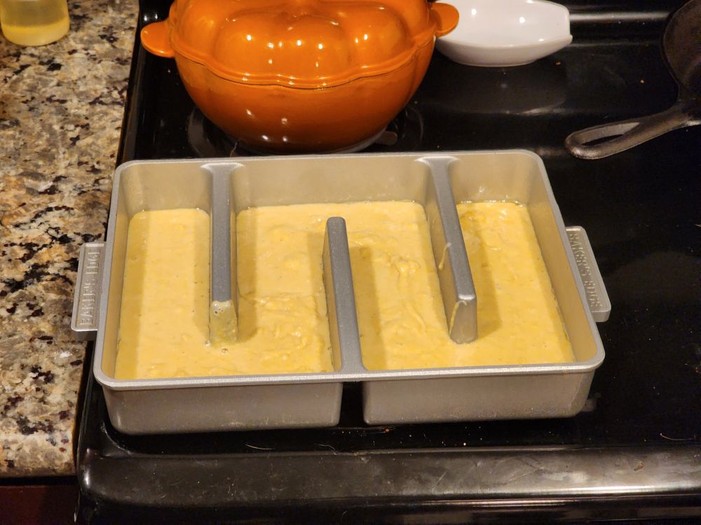 An "all edges brownie pan" filled with cornbread batter