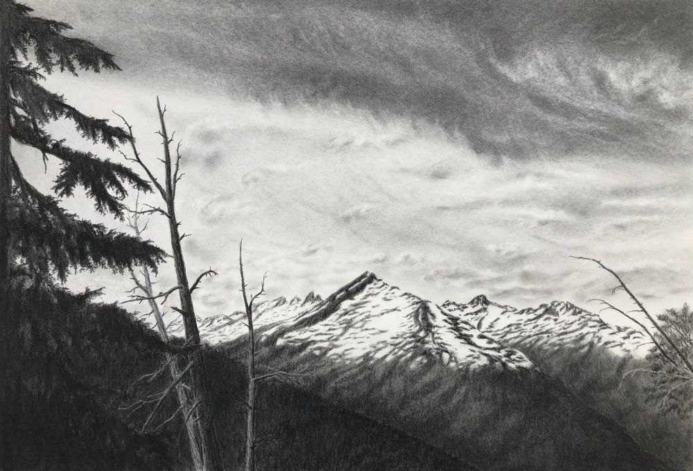 Sunset over distant mountains in charcoal 