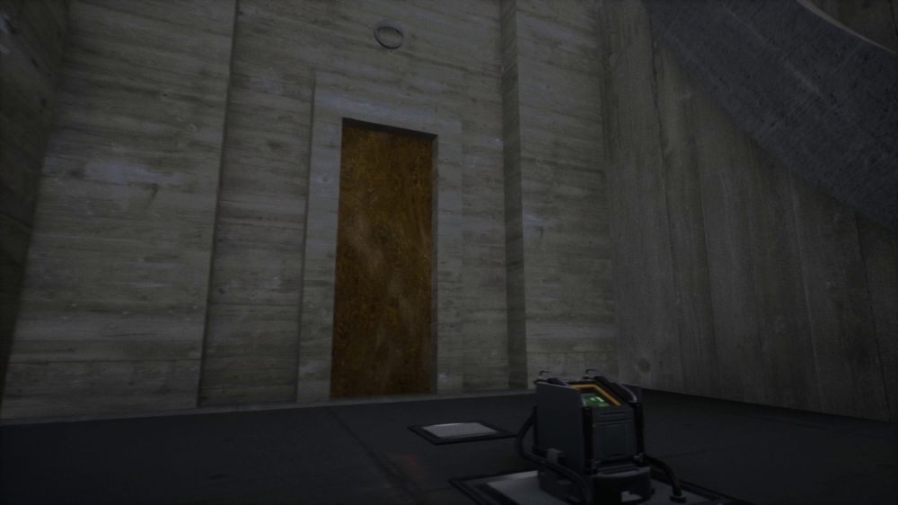 Big concrete cell door with unknown machinery in front of it.