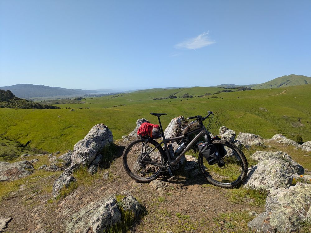 Loaded bike leaning against rocks.