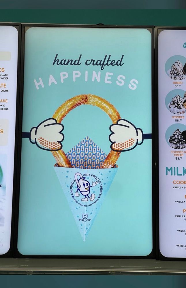 an advertisement for some sort of ring shaped dessert, with two cartoon hands, one holding onto it from each side. there is no ring. well there is a ring but not a finger ring