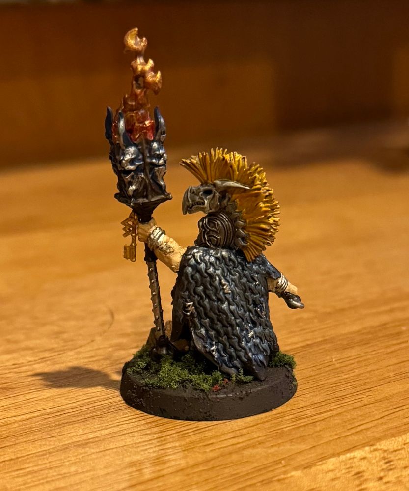 The back of the Auric Runemaster from Warhammer with blue and metallic cloak and tribal headpiece. 