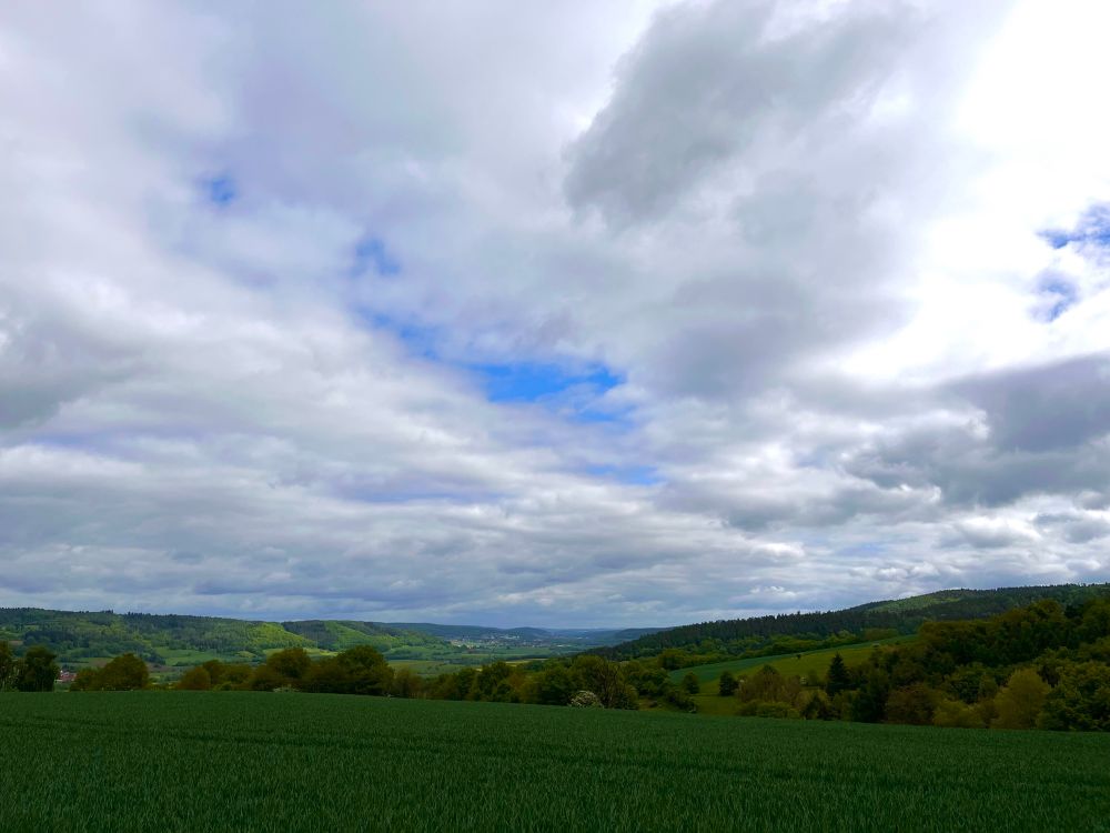 Wolkenbild, mit sanften Hügeln und satt grünen Feldern