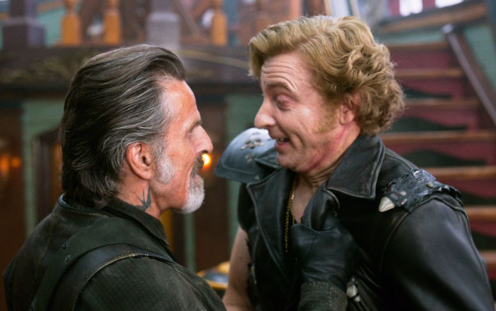 izzy hands grabbing stede "the legendary blackbeard" bonnet by the leather jacket, stede has just turned towards izzy and is smiling happily (our flag means death s1e4)