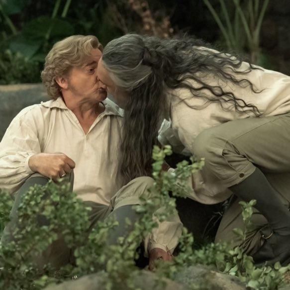 ed teach kneeling to give stede another kiss before running off to mug a guy for a dinghy, stede is surprised yet again (our flag means death, technically s1e9, this is from some random video hbo max dropped because they're monsters gatekeeping extra kisses and other goodies) 