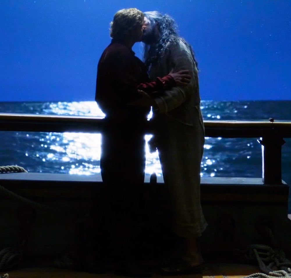 ed teach holding the fish he caught while being held by the fish he caught, kissing stede in the moonlight on the revenge (our flag means death s2e5)