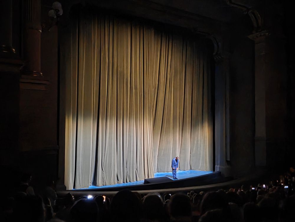 Christian Thielemann steht alleine auf der Bühne im Bayreuther Festspielhaus und verbeugt sich vor dem geschlossenen Vorhang