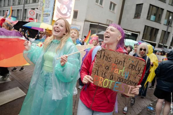 Menschen auf CSD Demo mit Schild "This isn't only a party it is a goddamn protest"