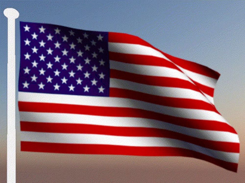 an american flag is waving in the wind with a blue sky in the background