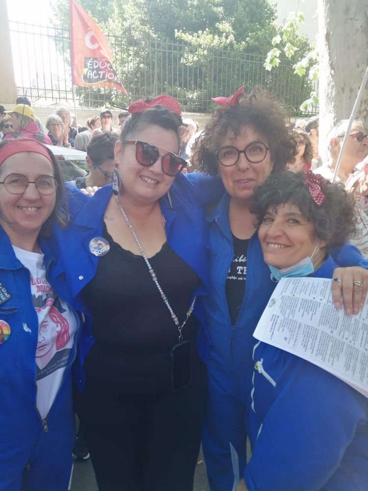 Des Rosies de Narbonne en bleu de travail, slogans à la main, pendant la manifestation 1er mai