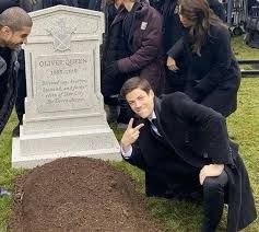 Guy leaning dramatically over a grave.