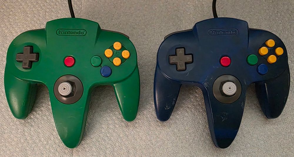 Blue and green Nintendo 64 controllers before cleaning and stick repair. 
