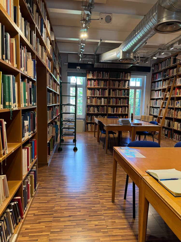 Photo showing bookshelves, large tables, and rolling ladders in the CAARI library in Nicosia