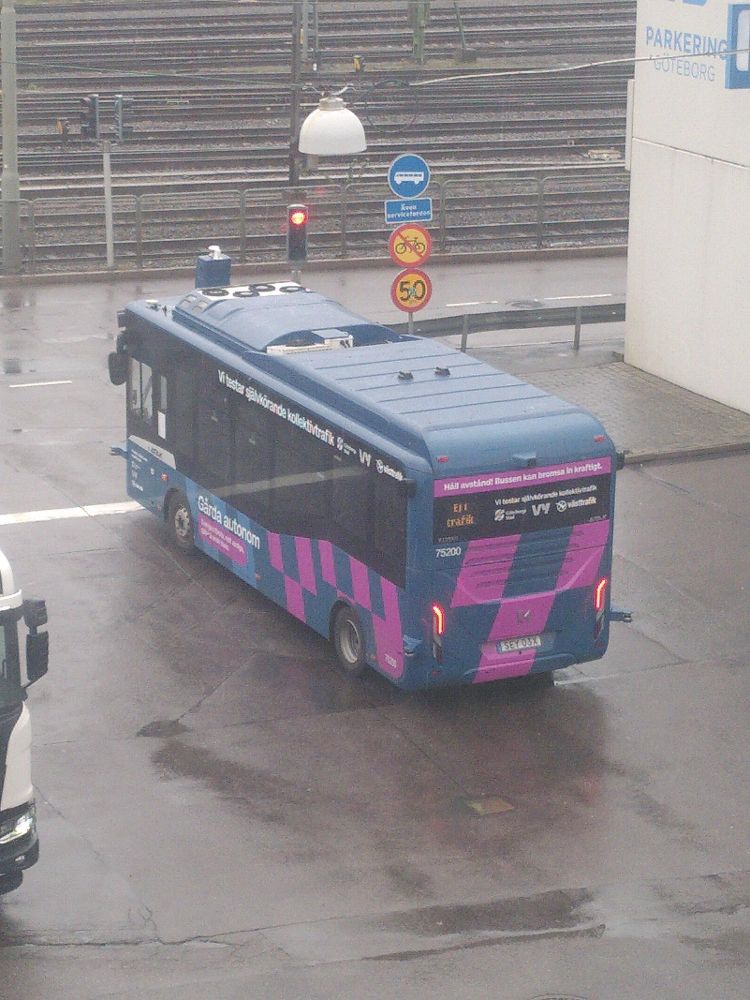 Foto av en buss från Västtrafik. Den har massa text på sig, bl.a. "Håll avstånd! bussen kan bromsa in kraftigt!" och "Vi testar självkörande kollektivtrafike".