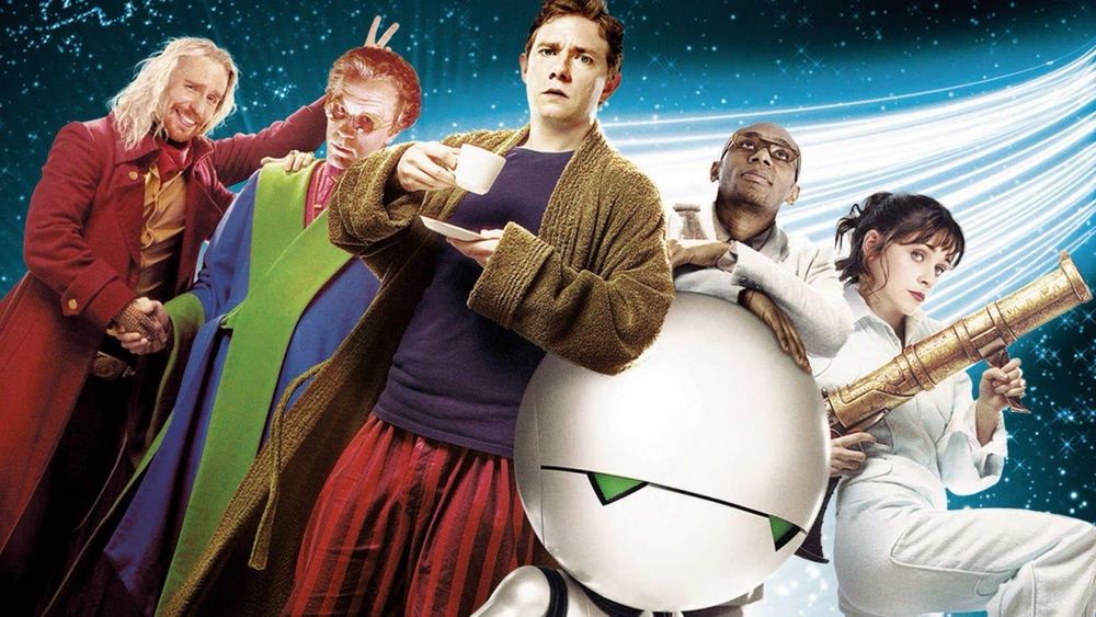 Cast photo of Hitchhiker’s Guide to the Galaxy, showing Beeblebrox, antagonist, Arthur Dent, Marvin the Paranoid Android, Ford Prefect, Trillian; set against background of stars and hyperspace whoosh