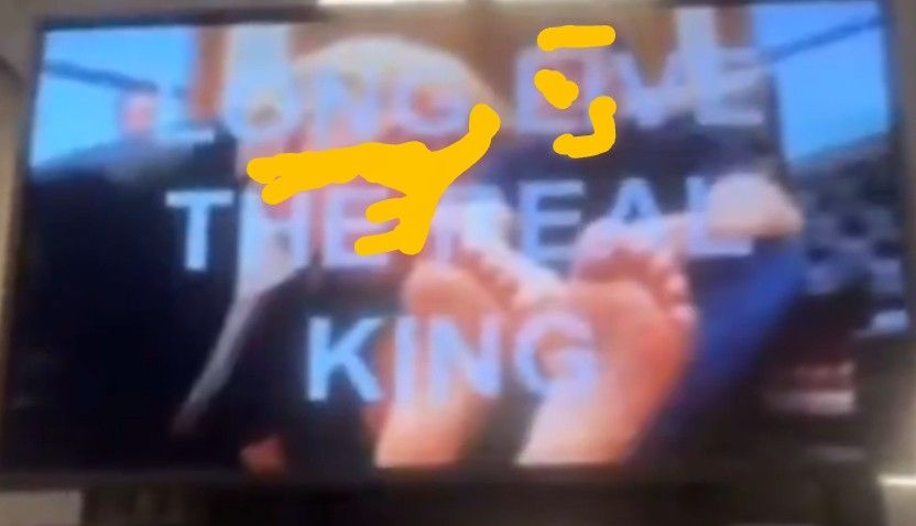 The faces of trump and elon are marked out as trump is licking the toes of elon musk. It is a screenshot taken from the video that played in the cafeteria of HUD headquarters. It has all cap letters LONG LIVE THE REAL KING. It is an obvious AI video, musk has two left feet.