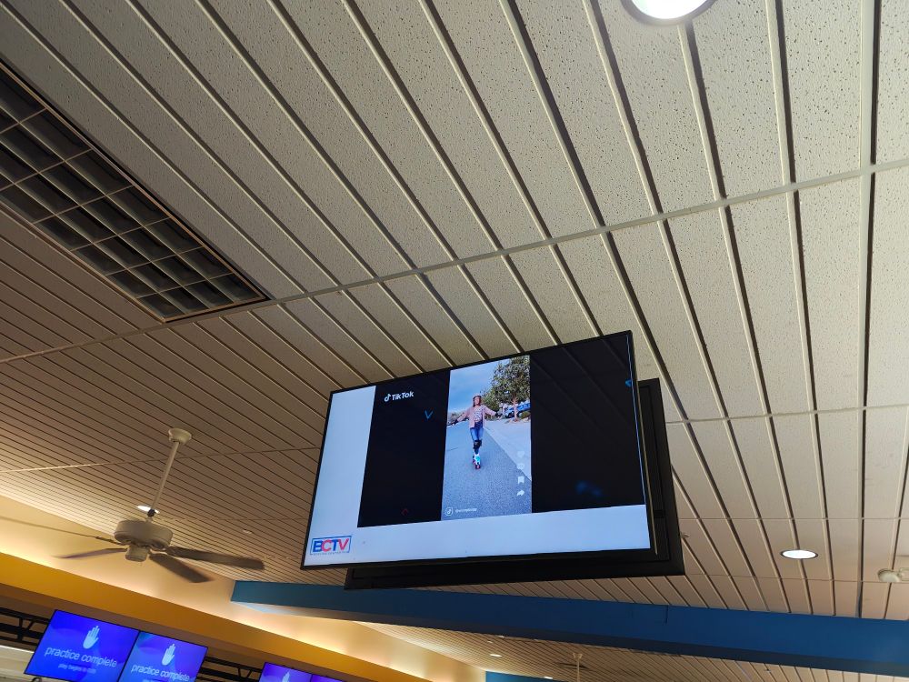 A roof mounted tv playing a very poorly formatted TikTok video