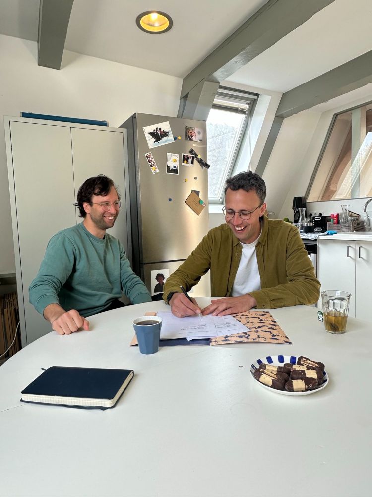 Hier teken ik een contract voor het boek. Op de tafel staan ook bokkenpootjes, die we daarna aten om het tekenen te vieren.