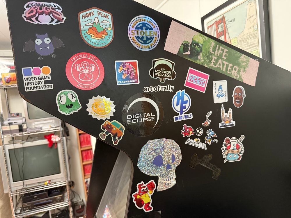 Arcade machine from the side with lots of stickers
