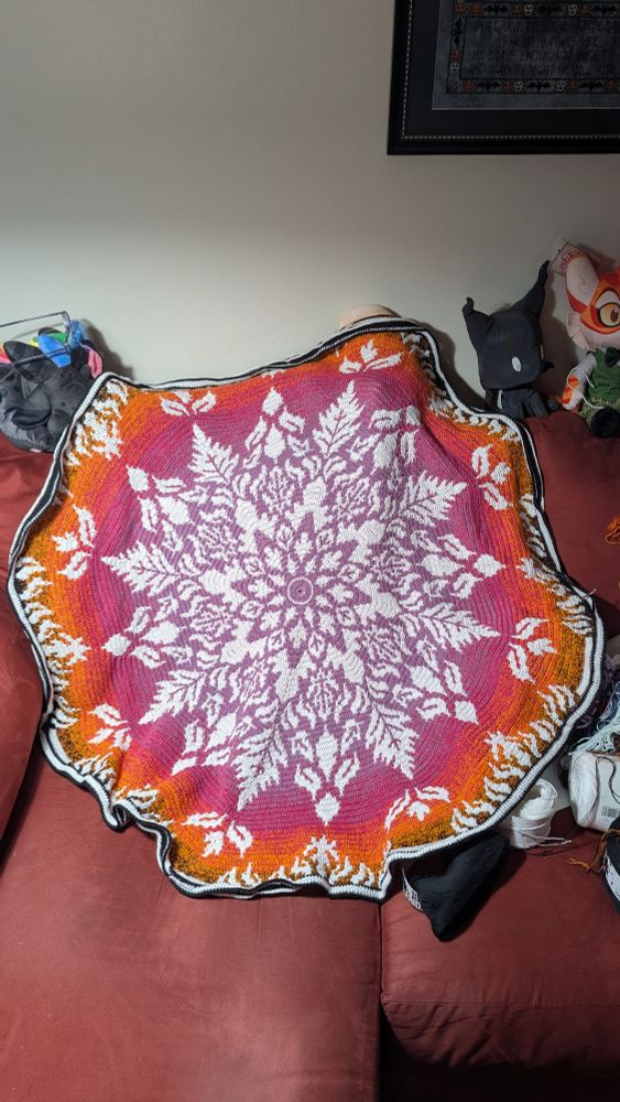 Mosaic crochet blanket with an autumn theme. White contrasting with a color changing yarn going from purple -> pink -> orange -> black.