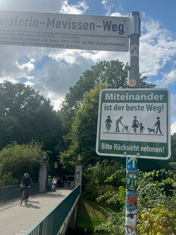 Neben einem Gemeinamen Geh- und Radweg ein Schild:
"Miteinander ist der beste Weg"
Piktogramme verschiedener Verkehrsteilnehmer
"Bitte Rücksicht nehmen!"
