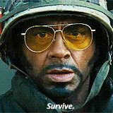 a man wearing a helmet and sunglasses says " survive " on the bottom