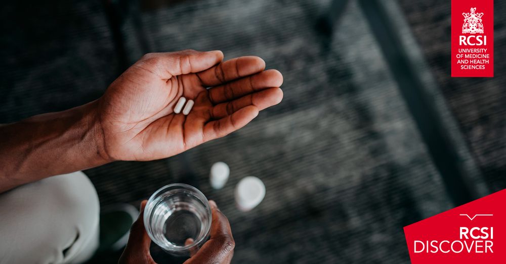 A close-up of a person’s hands holding two white capsules in one hand and a glass of water in the other, suggesting medication use. The image includes RCSI University of Medicine and Health Sciences and RCSI Discover branding.