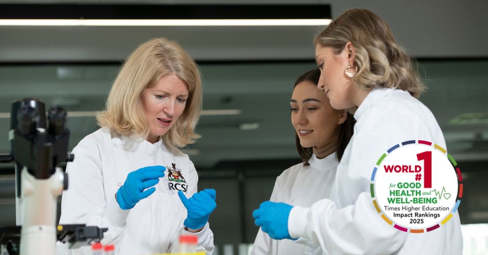 A female RCSI researcher in a white lab coat and blue gloves instructs two younger students in a modern laboratory setting. They are examining a scientific sample together, with a microscope and laboratory equipment visible on the bench. All three women are focused and engaged. The RCSI crest is visible on the lead researcher's coat. A badge overlay in the bottom-right corner reads: "World #1 for Good Health and Well-being – Times Higher Education Impact Rankings 2025".