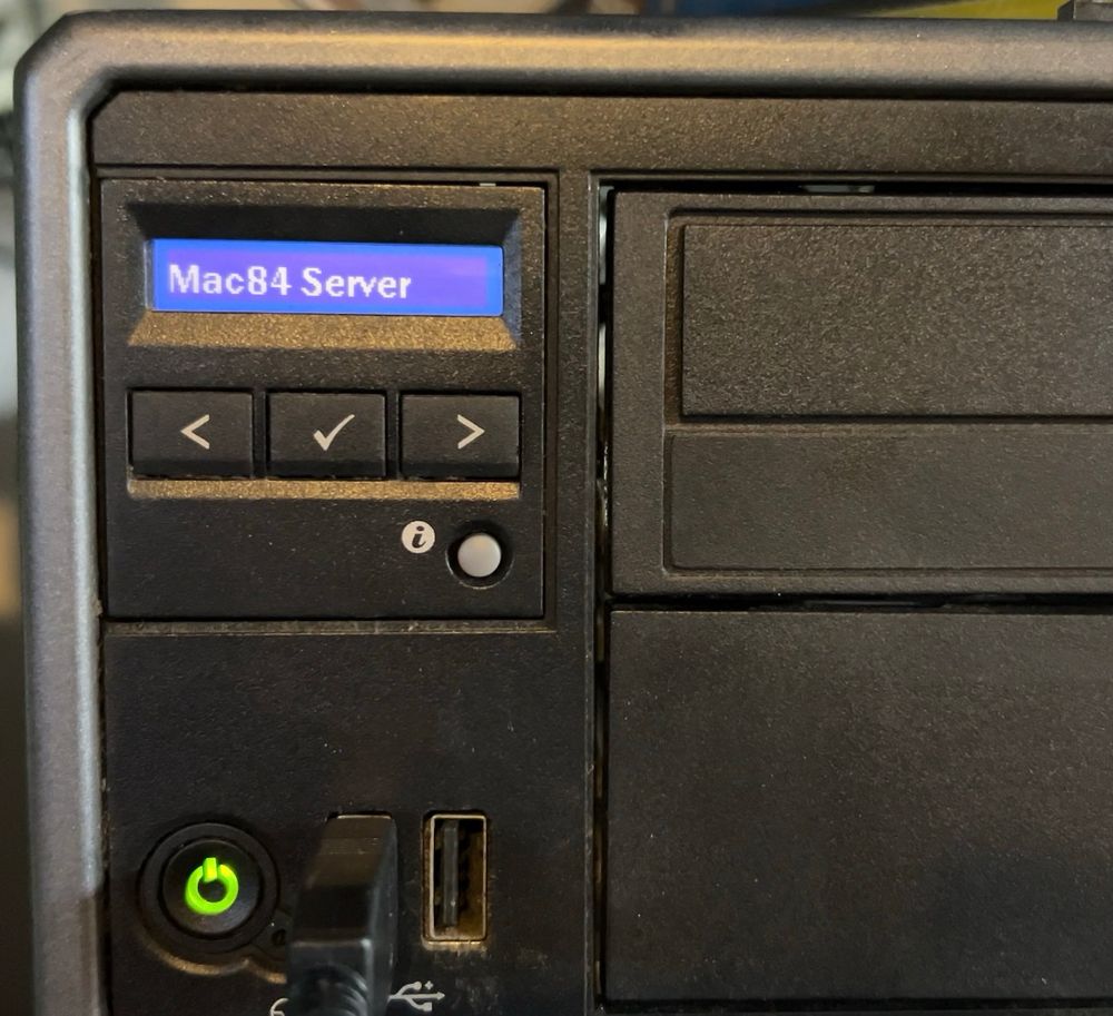 A desktop computer with a small LCD screen that reads “Mac84 Server”.