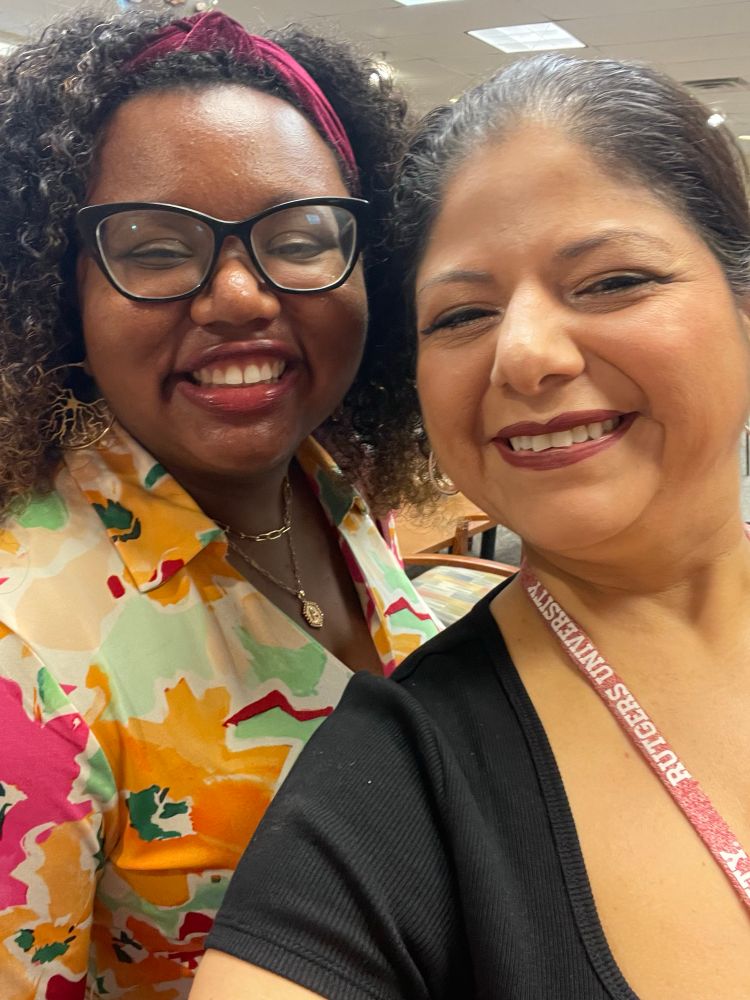 A selfie of Dr. Angeline Dukes and Dr. Kaliris Salas, a Black woman and Puerto Rican woman neuroscientists. Both women are smiling widely inside a classroom