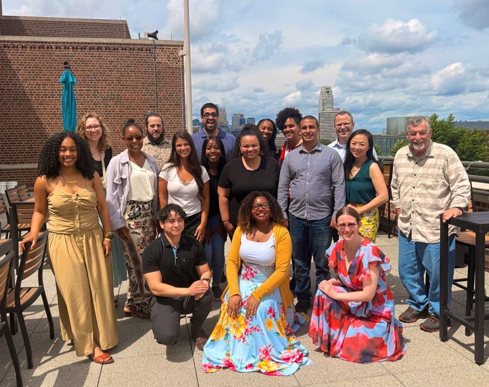 A group photo during the last official meeting of the Diversifying the Community of Neuroscience longitudinal mentorship program. The group of faculty, postdoctoral fellows, and physicians are smiling for a photo on an outdoor terrace at the University of Minnesota campus.