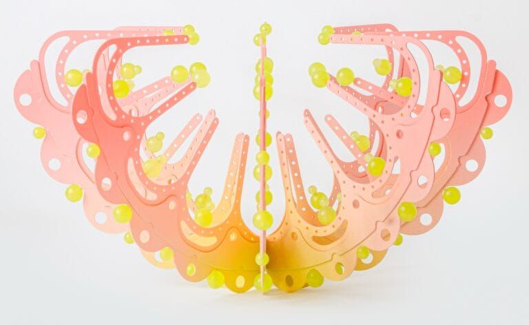 a pink and yellow curved sculpture with scalloped edges