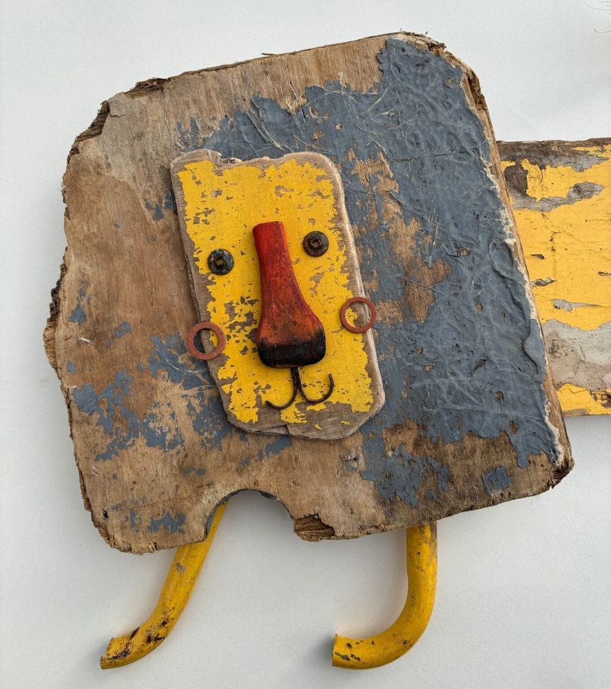 a lion sculpture made of worn yellow wood