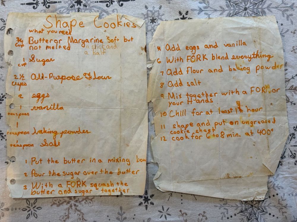 A recipe for "Shape Cookies", written in orange marker by a child. The paper is old and deteriorating.