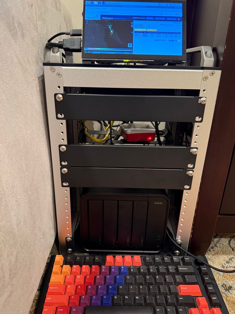 Mini computer rack with colorful computer keyboard in front of it 