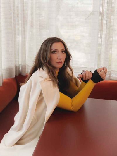 Chelsea Peretti sitting at a table