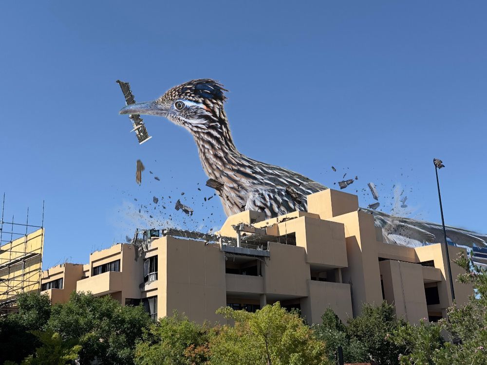 Photoshopped image of a massive roadrunner with a chunk of the humanities building in its mouth.