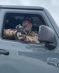 ICE/CBP officer pointing gun out of truck window