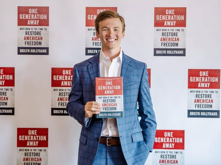 Brilyn Hollyhand holding his book "One Generation Away: Why Now Is The Time to Restore American  Freedom"