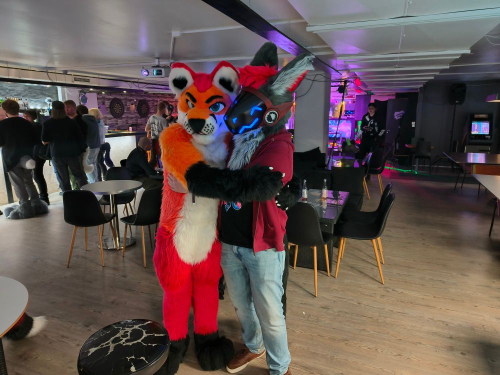 Picture with two fursuitters at a furry dance event