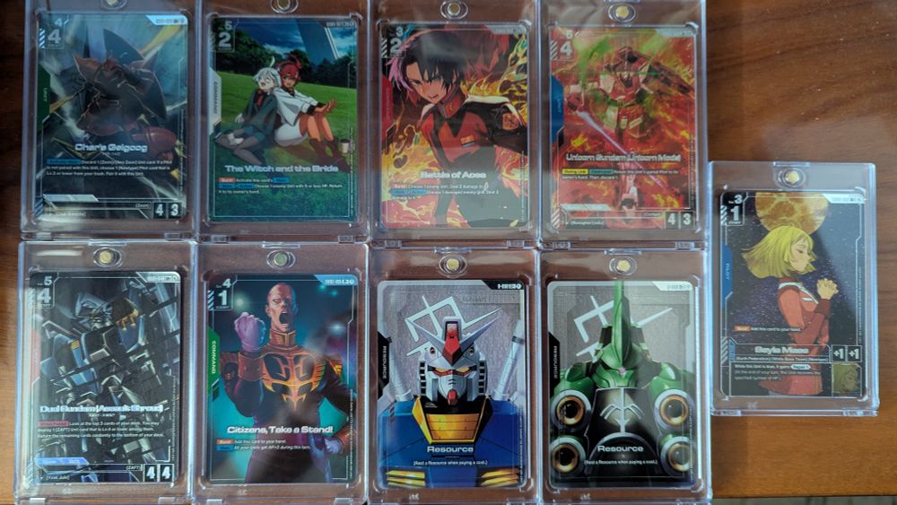 Cartas con arte alternativo del Gundam Card Game en fundas de plástico dura