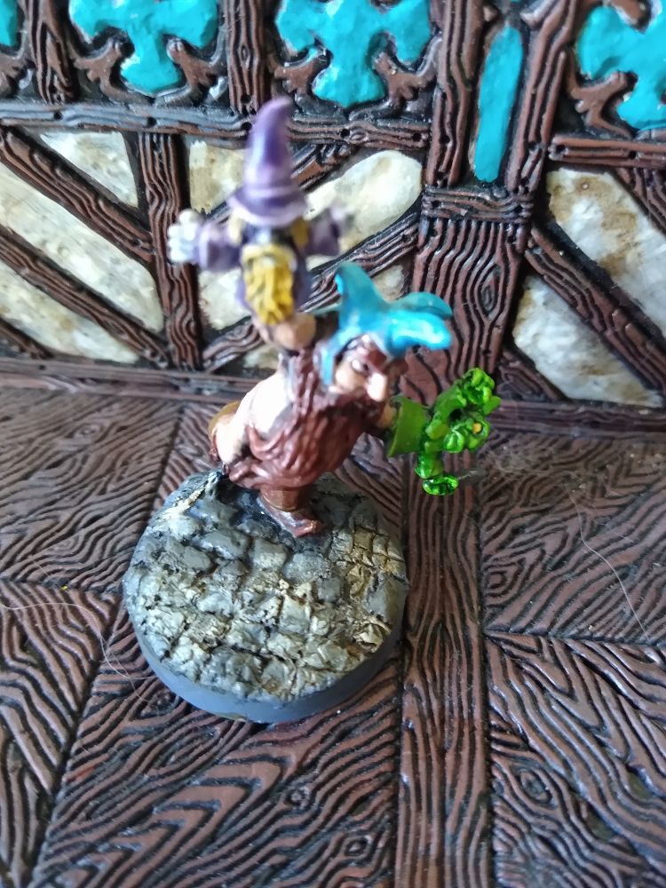 Figurine de nain qui porte un chapeau des bottes et a des marionnettes sur les mains . Sa barbe fait que la figurine reste pg13