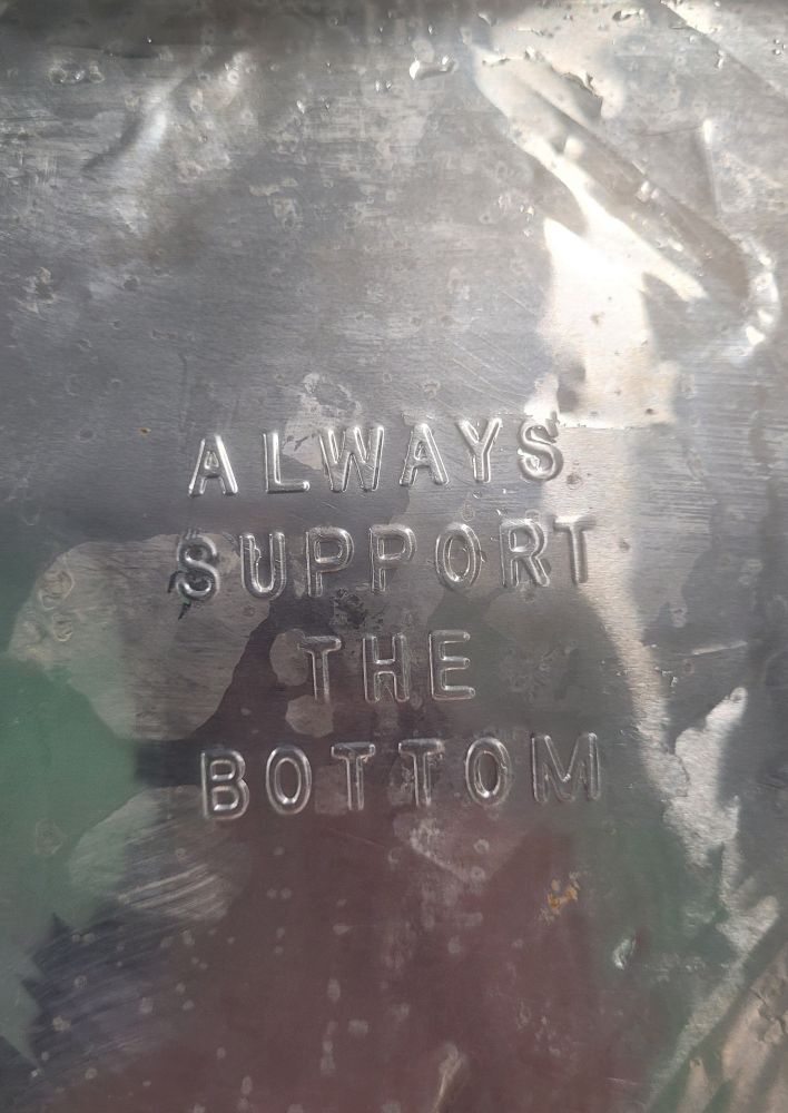 An aluminum tray embossed with "ALWAYS SUPPORT THE BOTTOM"