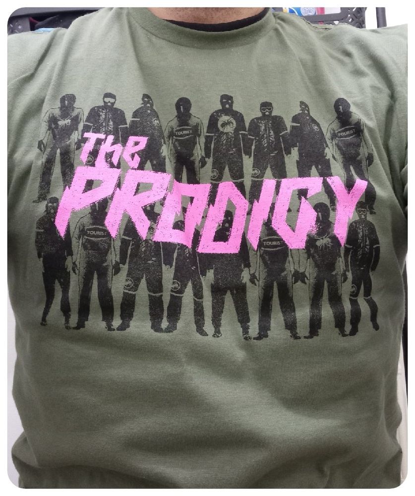 T-shirt vert du groupe The Prodigy intitulé Army. 
Ça reprend le backdrop de la tournée avec des personnages cagoulés et le logo du groupe en rose au milieu.