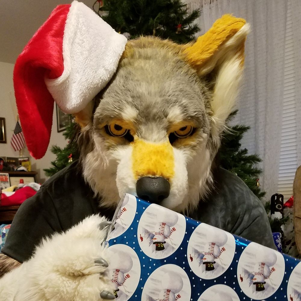 Lykanos with a dramatic glare, holding a present, and wearing a little Santa hat on one ear.