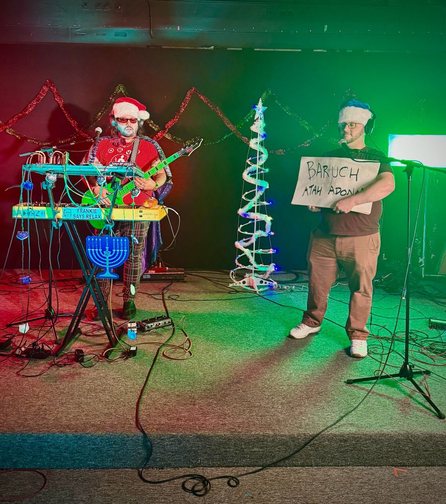 Chaki the Funk Wizard behind the jets, Harri holds cue cards 