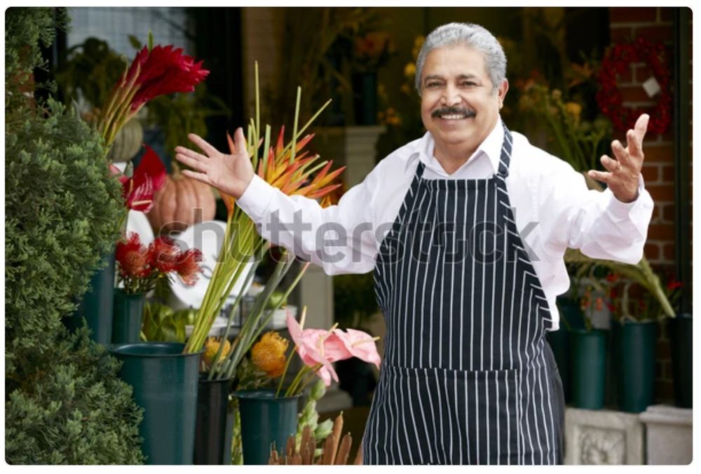 A watermarked stock photo of an older Italian gentleman in an apron, a shop owner of some kind, stepping up with a smile and his arms open in greeting. It’s the same picture every day. Today he is humming a jaunty tune!